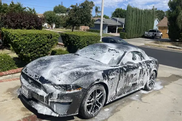 A snow covered car on the street is handled by Armando King Mobile Detailing using mobile car detailing.