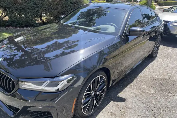 A BMW at a residential driveway is refreshed by Armando King Mobile Detailing using mobile car detailing service Los Angeles.