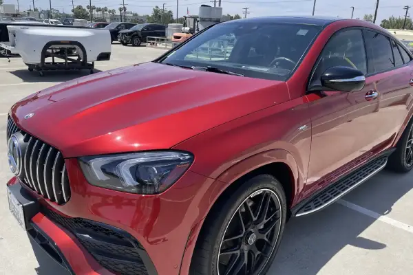 A red Mercedes SUV in the parking area is cleaned by Armando King Mobile Detailing with luxury vehicle mobile detailing.