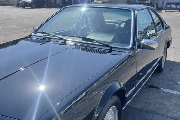 Armando King Mobile Detailing services a black BMW coupe at a building with mobile car detailing.
