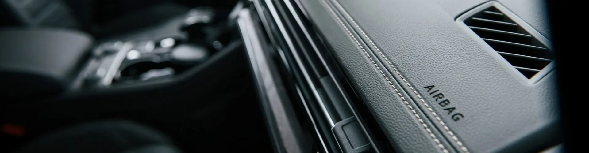 Armando King Mobile Detailing clears dust from a car air vent during mobile car detailing.