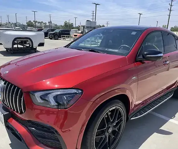 A red Mercedes SUV in the parking area gets luxury vehicle mobile detailing from Armando King Mobile Detailing.